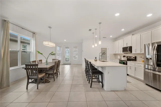 a large kitchen with a table and chairs