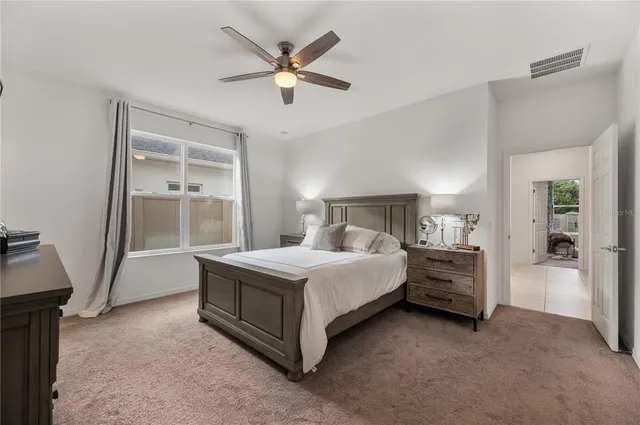 a bedroom with a bed and a ceiling fan