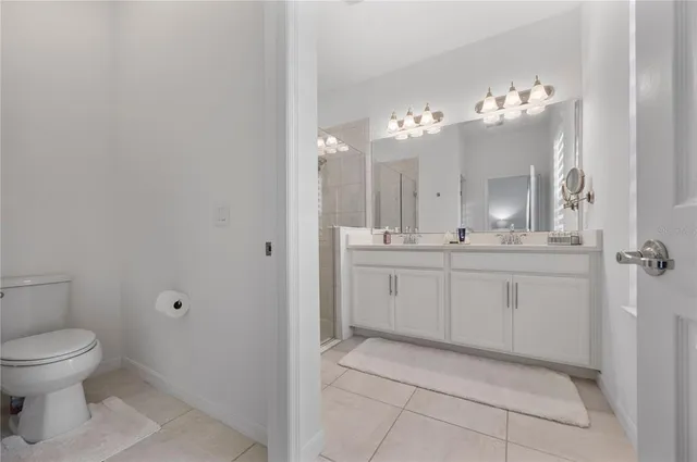 a bathroom with a double vanity sink mirror and shower