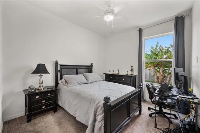 a bedroom with a bed and a computer on the desk