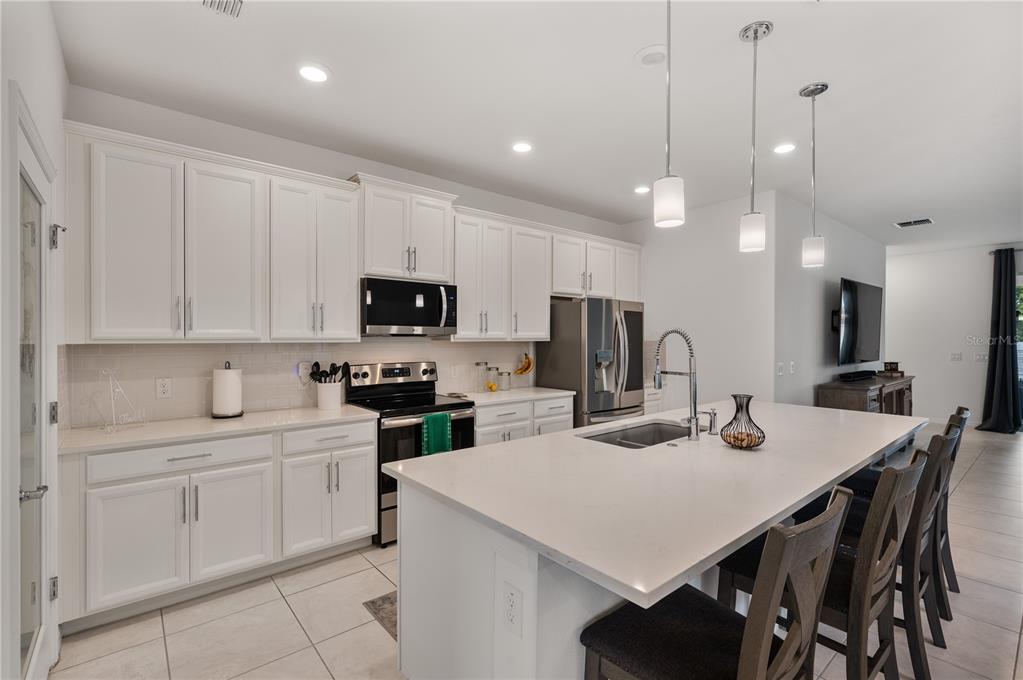 2887 Parkfield Road St. Cloud, FL 34772 - Photo 10 of 51 a kitchen with white cabinets and stainless steel appliances
