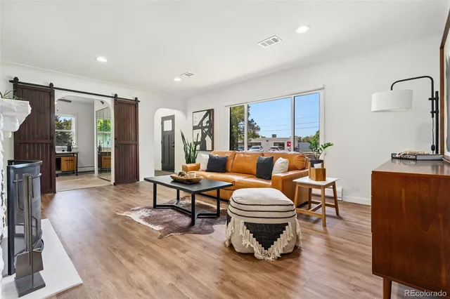 a living room with furniture a fireplace and wooden floor