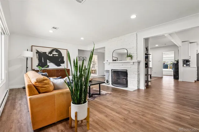 a living room with furniture a fireplace and wooden floor