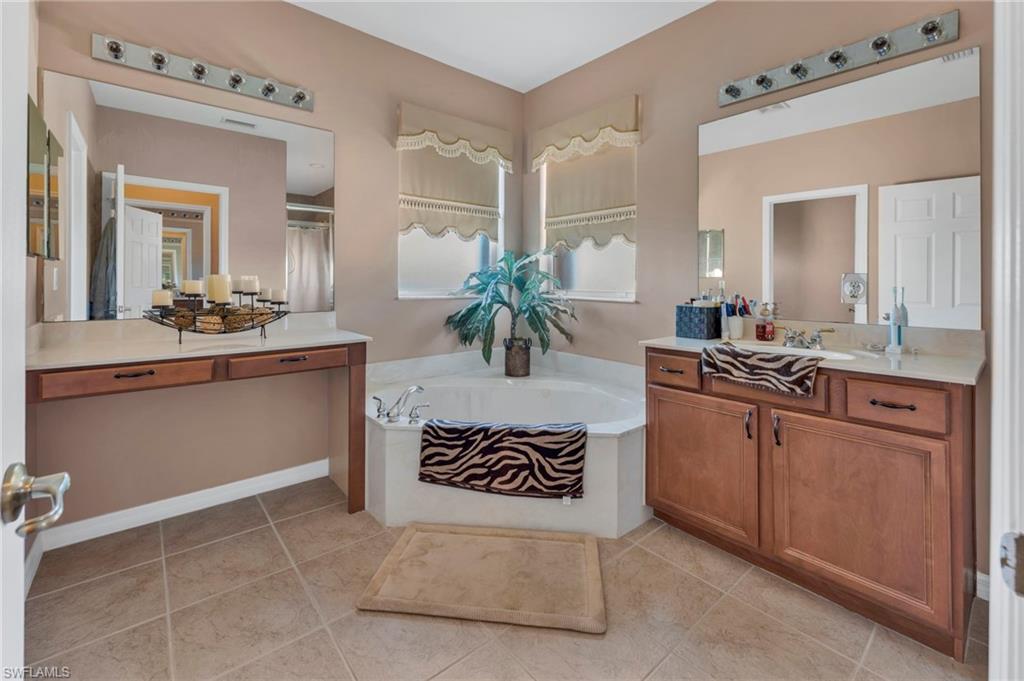 1966 Par Drive Naples, FL 34120 - Photo 11 of 32 Bathroom featuring a bath, vanity, light tile patterned floors, and a shower