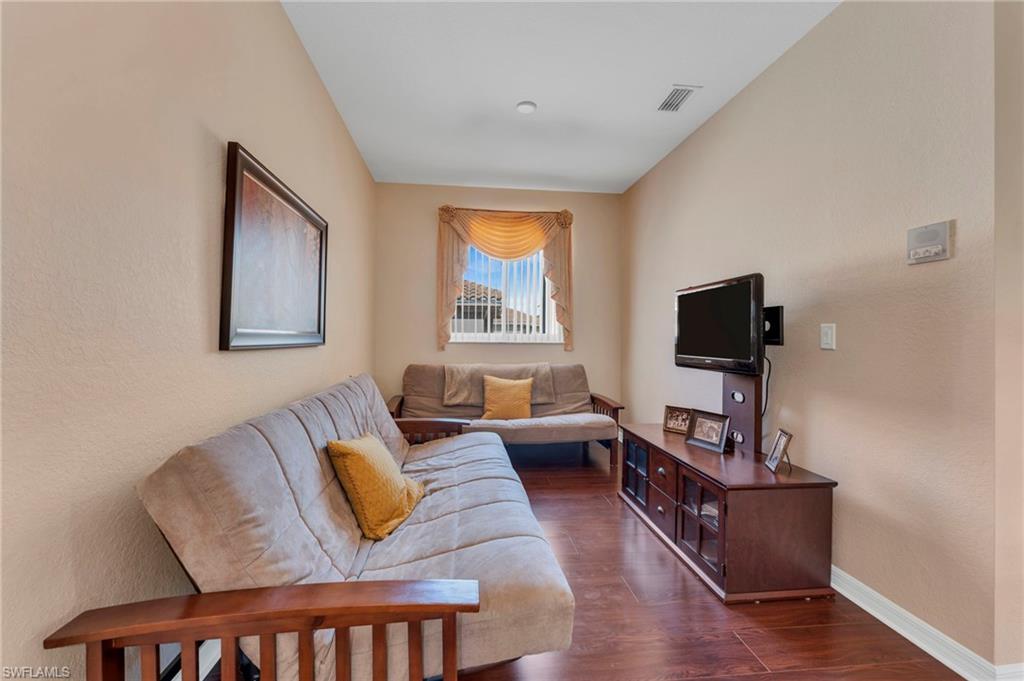 1966 Par Drive Naples, FL 34120 - Photo 3 of 32 Living area featuring dark wood-style floors and a textured wall