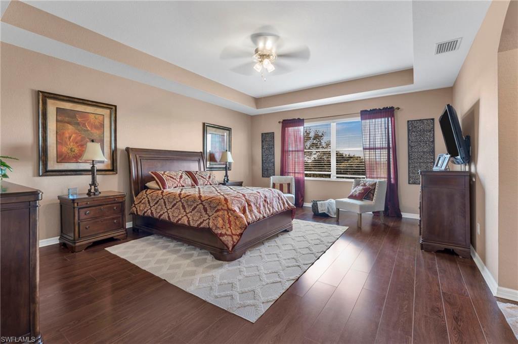 1966 Par Drive Naples, FL 34120 - Photo 9 of 32 Bedroom with a tray ceiling, dark wood-type flooring, and ceiling fan