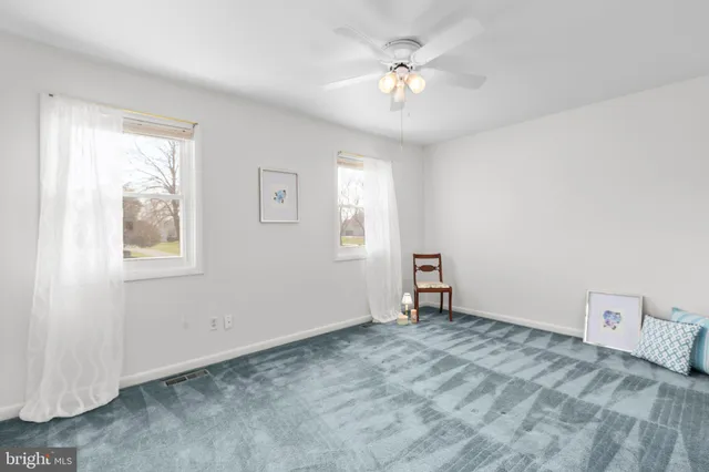 an empty room with a window and a ceiling fan