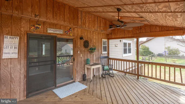 a view of a lake with chairs and wooden fence