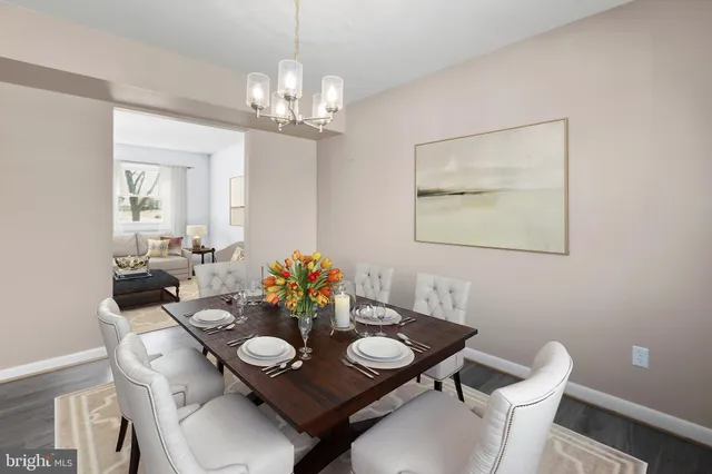 a view of a dining room and livingroom with furniture wooden floor a chandelier