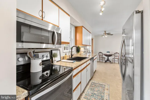 a kitchen with stainless steel appliances granite countertop sink stove and cabinets