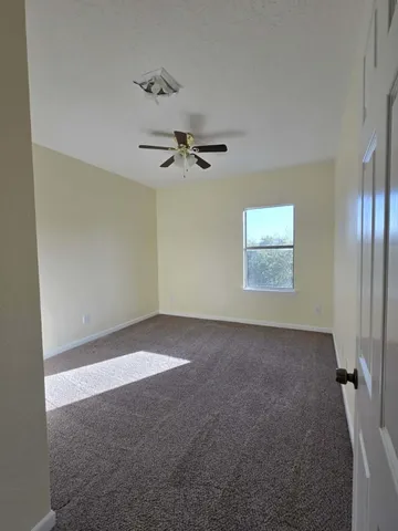 a view of an empty room with a ceiling fan