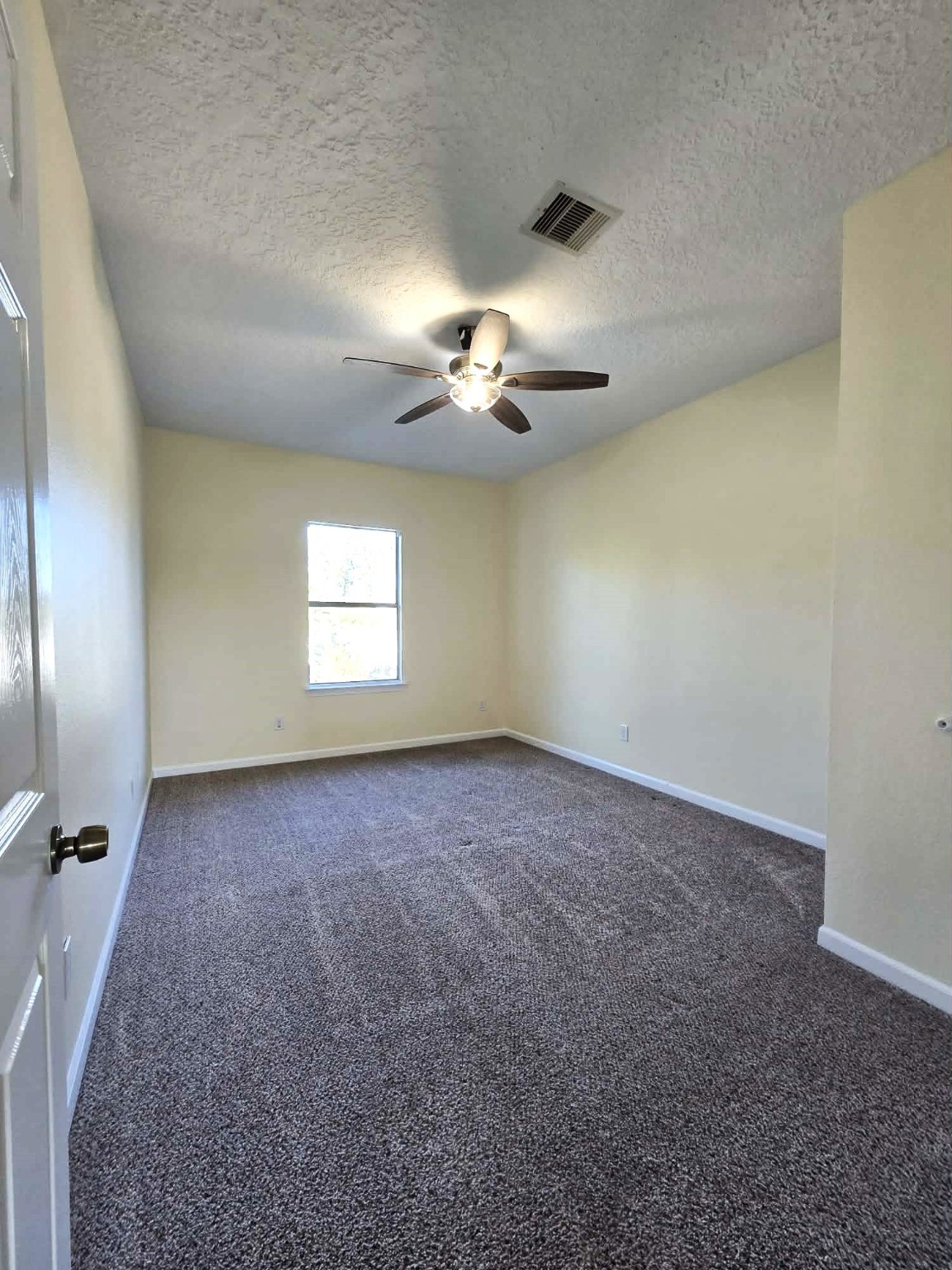6641 Midfield Drive Houston, TX 77092 - Photo 15 of 21 an empty room with a chandelier fan and windows