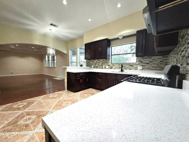 a kitchen with stainless steel appliances kitchen island granite countertop a sink and cabinets