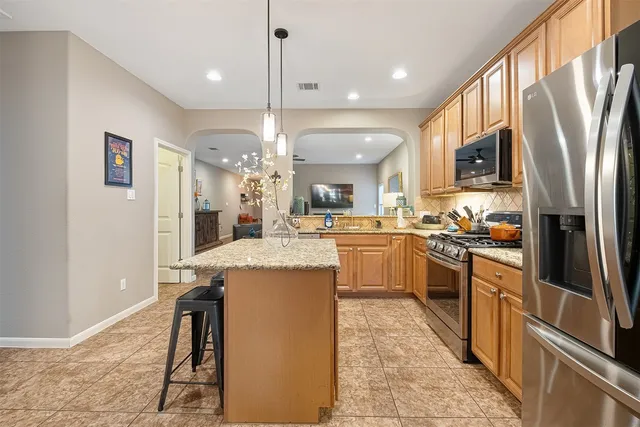 a kitchen with a sink a counter top space stainless steel appliances and cabinets