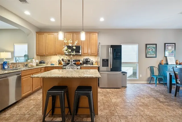 a kitchen with counter and chairs