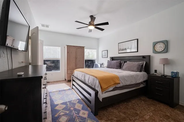 a bedroom with a bed and a flat tv screen on dresser