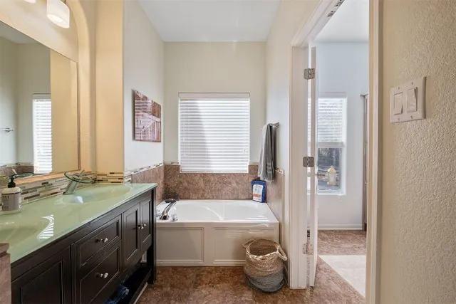 a bathroom with a granite countertop tub and a sink