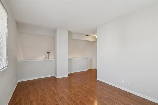 a view of empty room with wooden floor