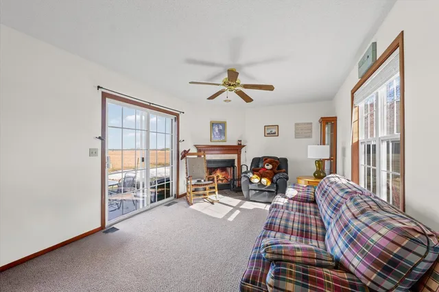 a living room with furniture a fireplace and a floor to ceiling window