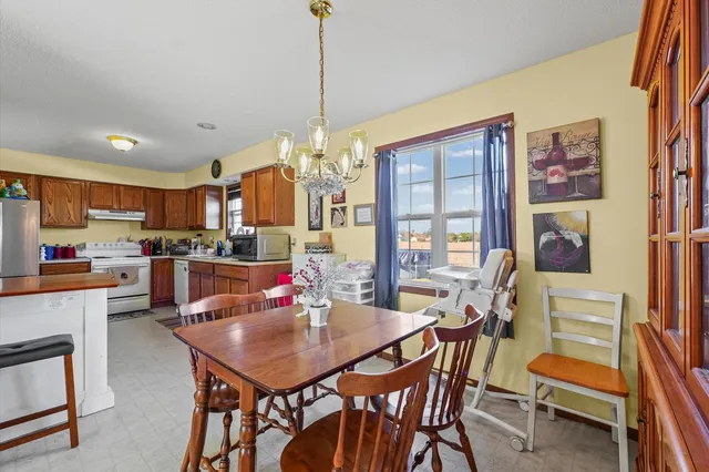 a view of a dining room with furniture and a chandelier