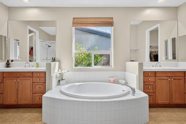 a bathroom with a tub sink and mirror