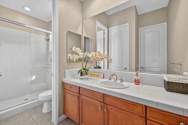 a bathroom with a granite countertop sink a toilet and a shower