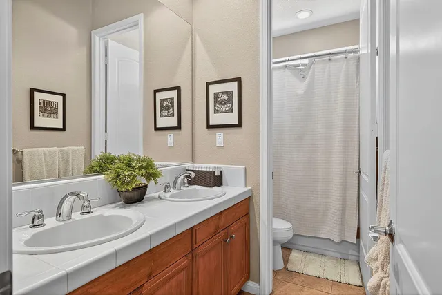 a bathroom with a granite countertop sink mirror vanity and toilet