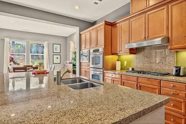 a kitchen with stainless steel appliances granite countertop a sink stove and cabinets