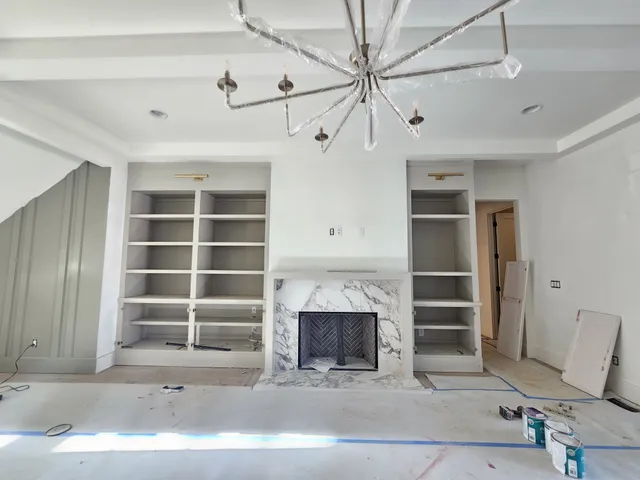 a large kitchen with granite countertop a sink dishwasher a stove and white cabinets with wooden floor