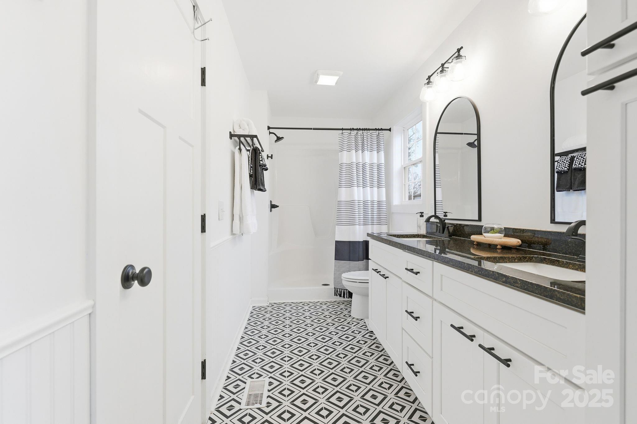 585 Stirewalt Road China Grove, NC 28023 - Photo 20 of 30 a bathroom with a double vanity sink a toilet a mirror and shower