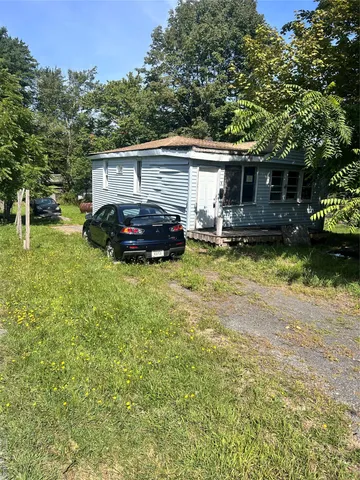 a view of a house with backyard and sitting area