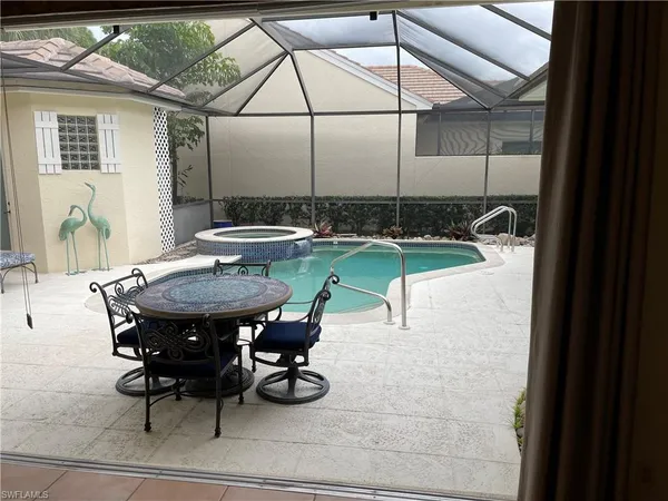 a view of a backyard with table and chairs under an umbrella