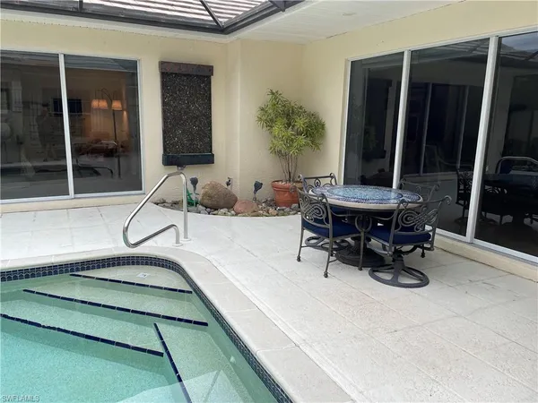 a dining room with glass top table and chairs