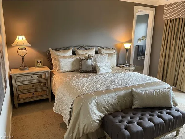 a bed sitting in a bedroom next to a lamp