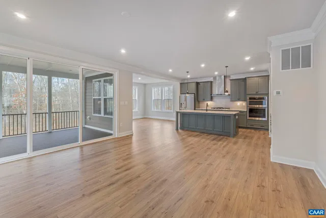 a view of a kitchen with wooden floor and a window