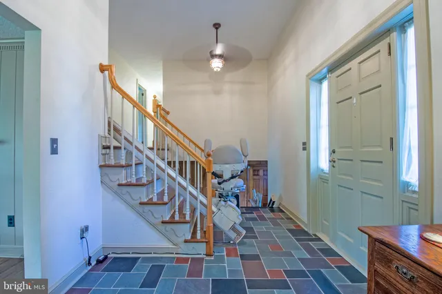 a view of a hallway with couches and a dining table chairs