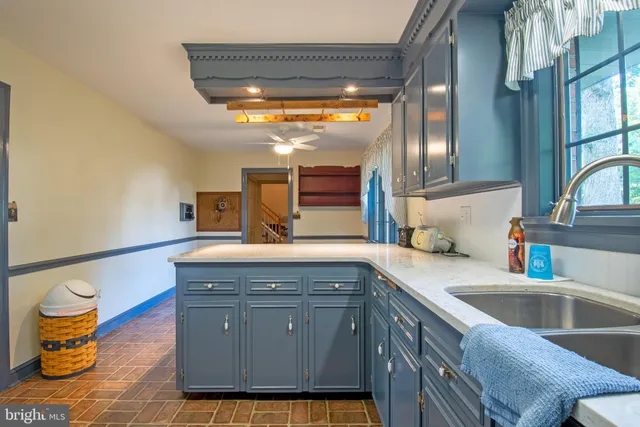 a view of a room that has a window and wooden cabinets