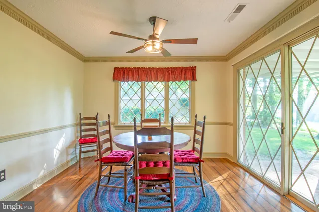 a dining room with furniture window and wooden floor