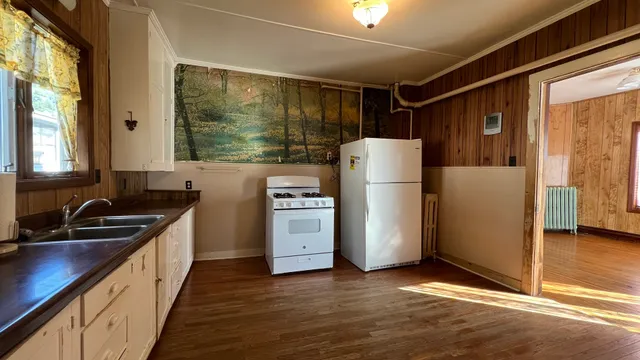 a kitchen with refrigerator a stove and a sink