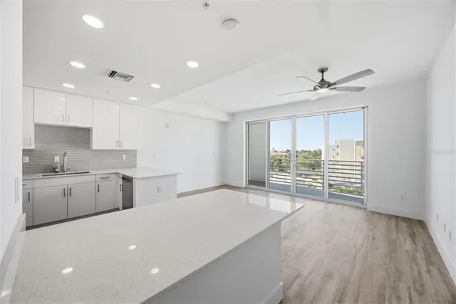 a view of a kitchen with a sink and dishwasher with wooden floor