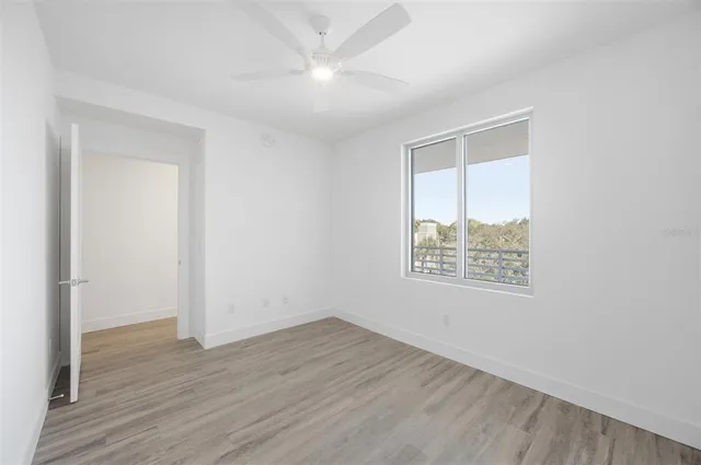 an empty room with wooden floor and window