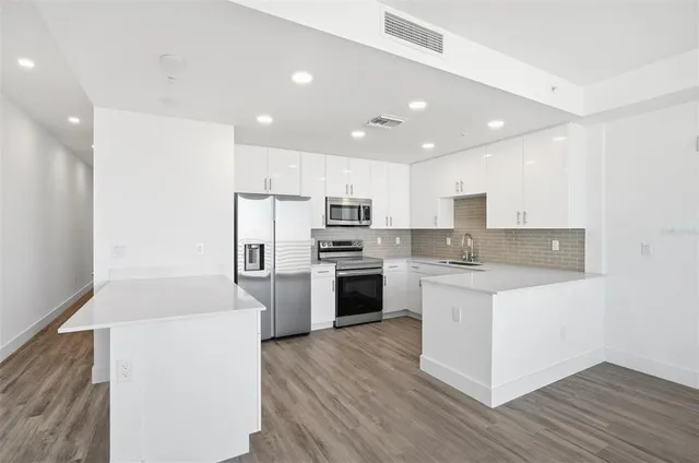 a kitchen with a refrigerator a stove top oven and kitchen island