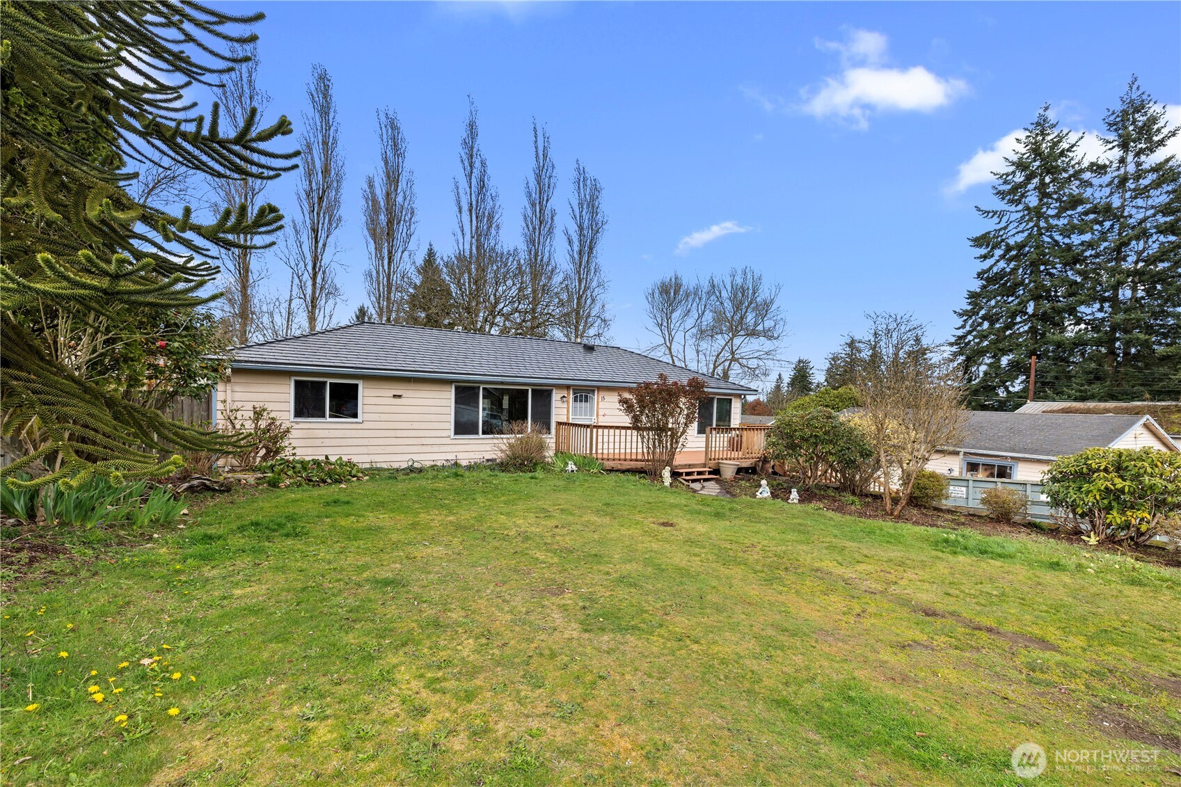 a view of a house with a big yard and large trees