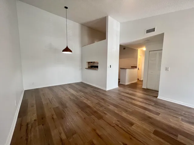 a view of a room with wooden floor and a ceiling fan
