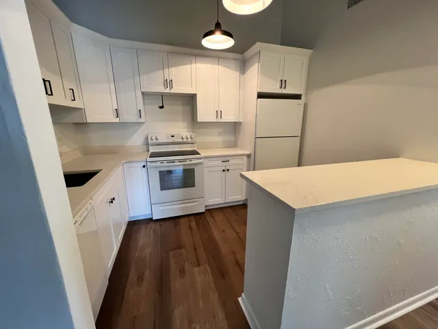 a kitchen with white cabinets and white appliances