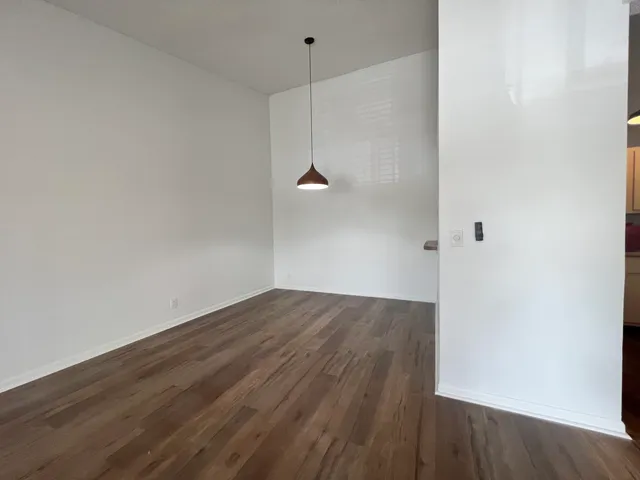 a view of a room with wooden floor and white walls