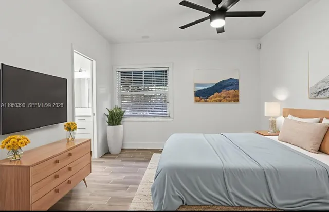 an empty room with wooden floor closet and windows