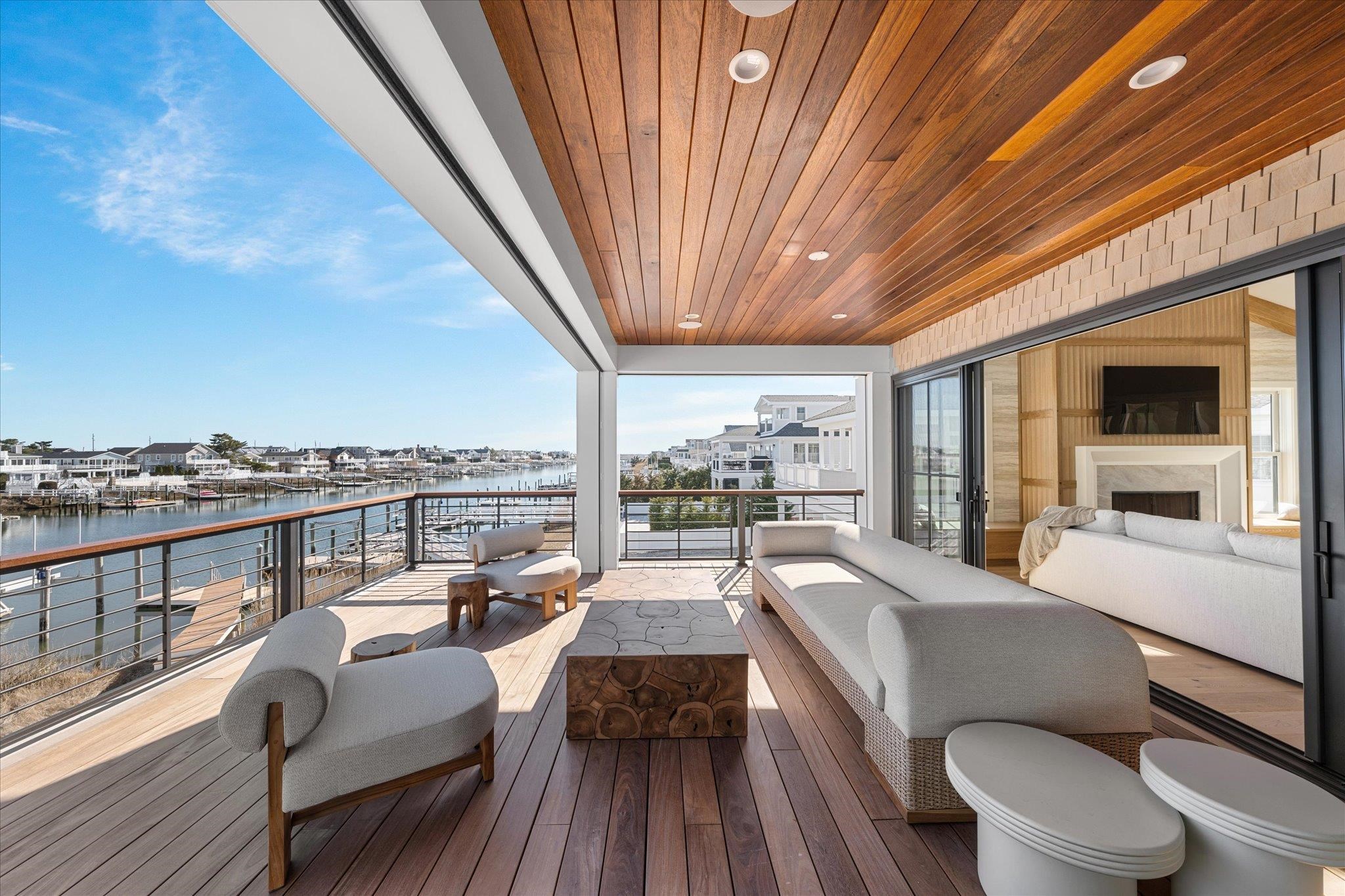 4277 5th Avenue Avalon, NJ 08202 - Photo 13 of 48 a view of a balcony with couch and wooden floor
