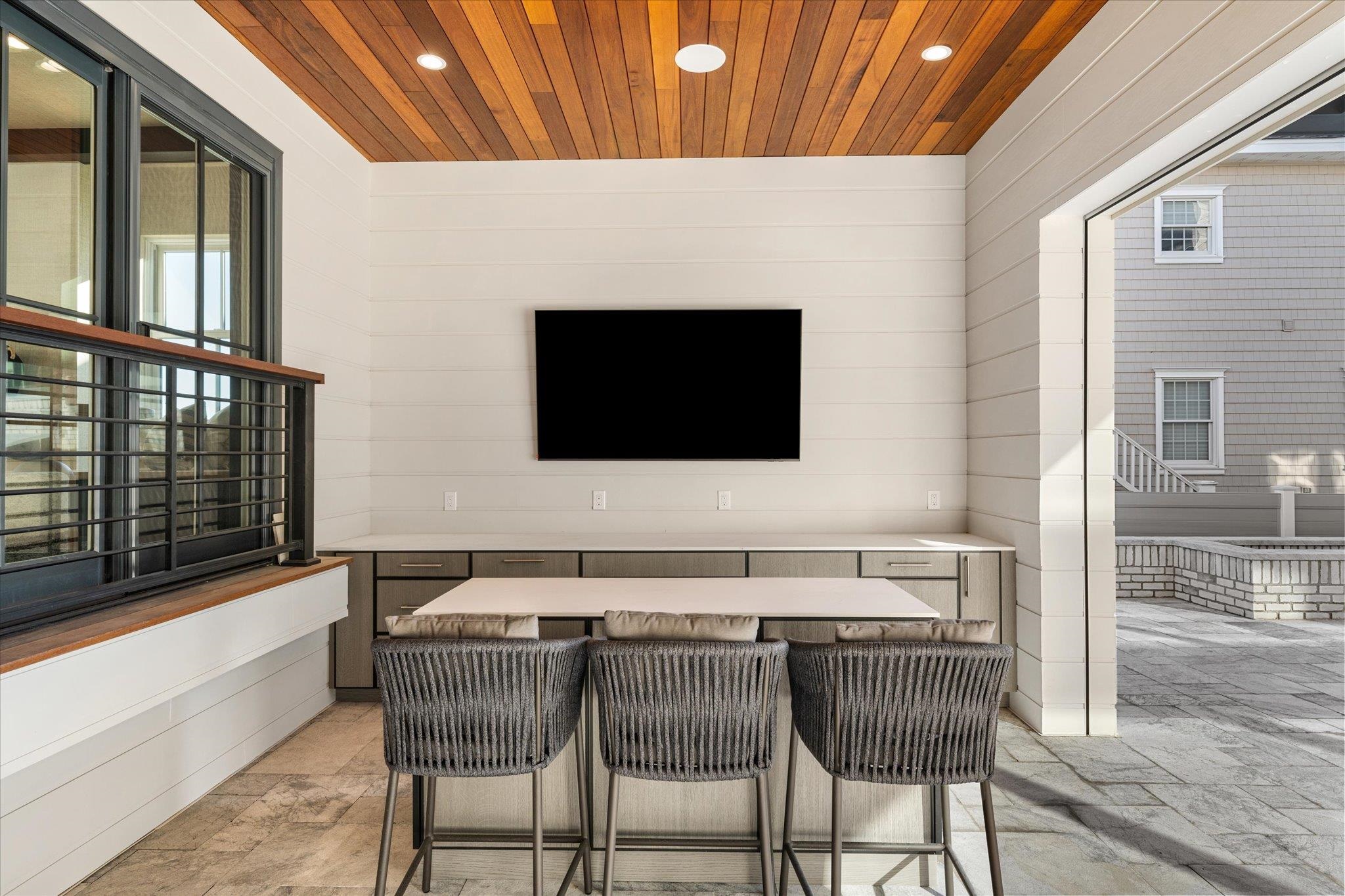 4277 5th Avenue Avalon, NJ 08202 - Photo 41 of 48 a view of a patio with table and chairs with wooden floor and fence