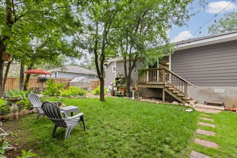 a view of a chair and table in backyard of the house